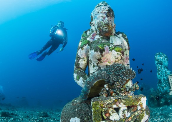 Underwater statue next to diver
